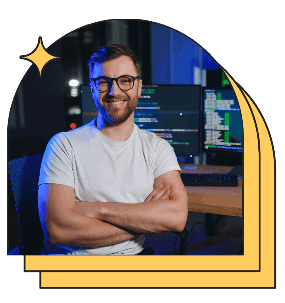 Chico sonriente con los brazos cruzados, ordenadores con contenido de desarrollo de aplicaciones multiplataforma online detrás de él.